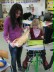 Helferin hilft Schülerin beim Brötchenschneiden.